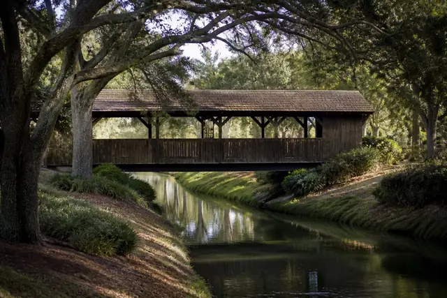 Coral Springs covered bridge crossing a quiet neighborhood canal beneath mature trees